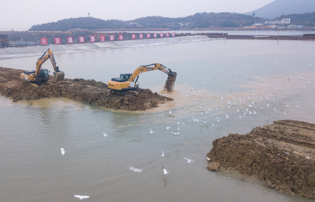2019年12月23日，鳥群從陸島轉(zhuǎn)換圍堰回水施工現(xiàn)場飛過。
